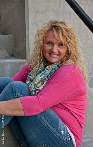 Pretty Smiling Woman Sitting on Stairs