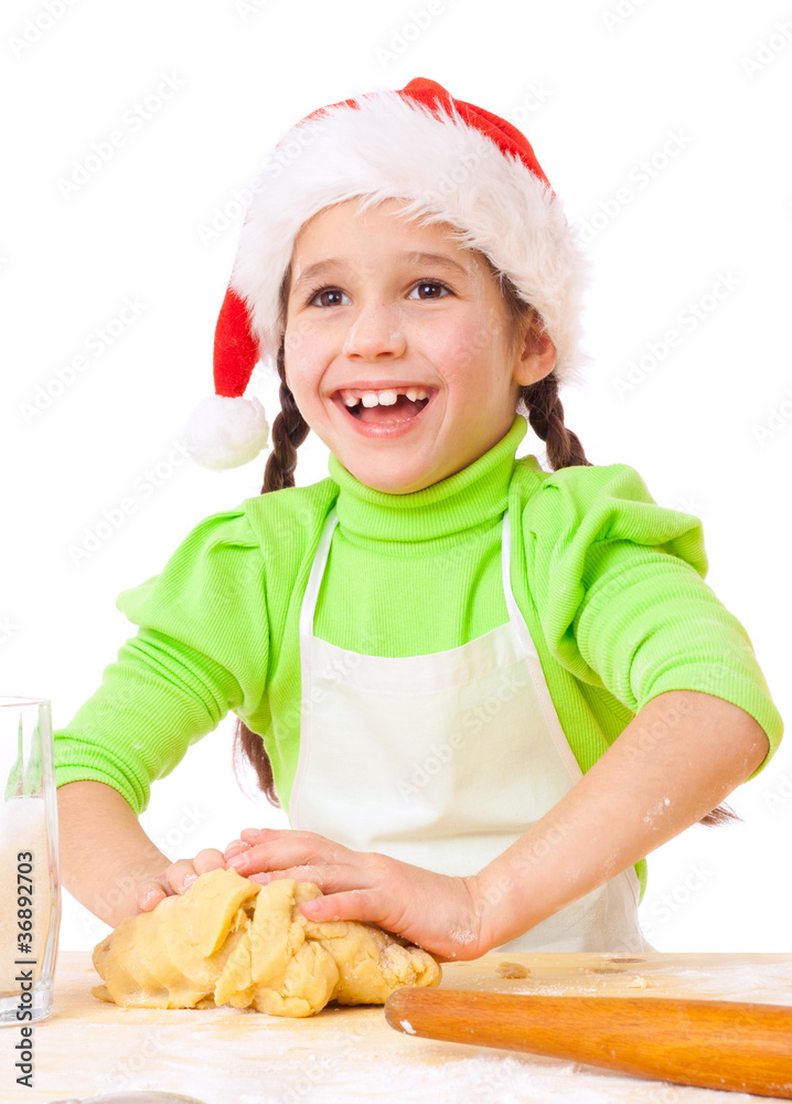 Smiling little girl kneading for Christmas cooking Smiling little girl kneading for Christmas cooking