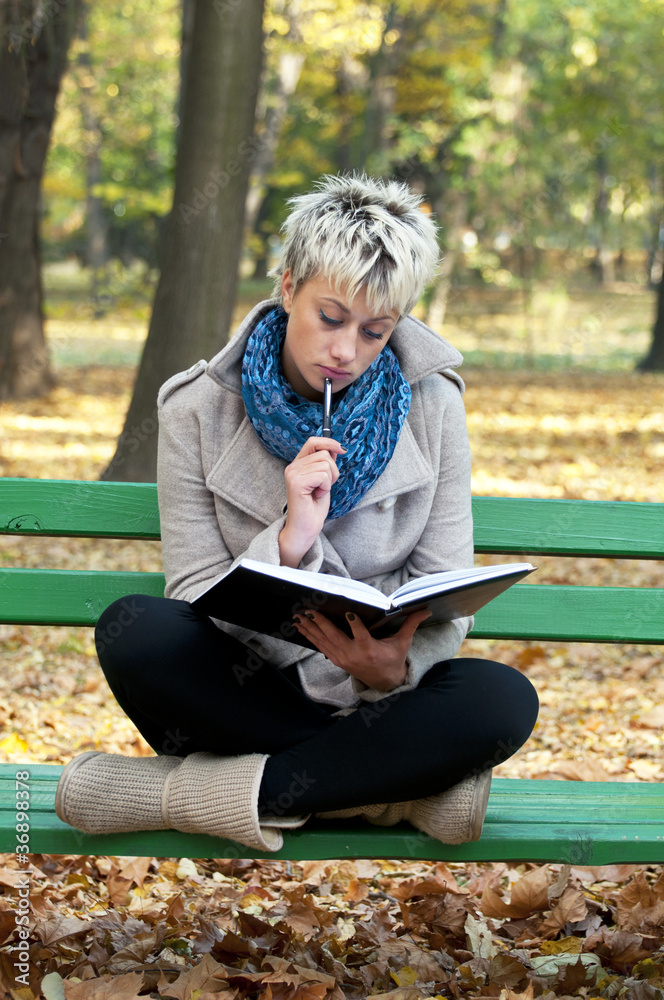 Beautiful girl studying outdoors reading a book Beautiful girl studying outdoors reading a book