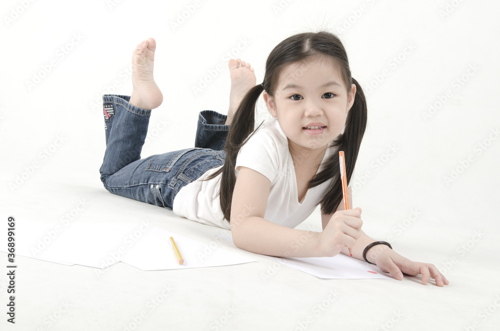 Little Asian girl drawing, lying on floor Little Asian girl drawing, lying on floor