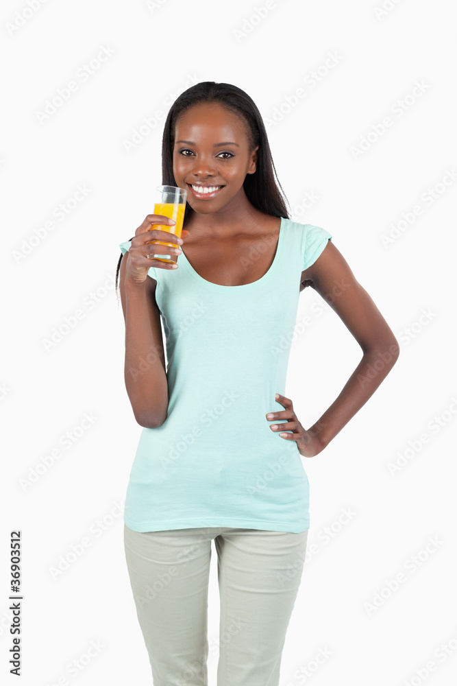 Smiling young woman having a sip of orange juice Smiling young woman having a sip of orange juice