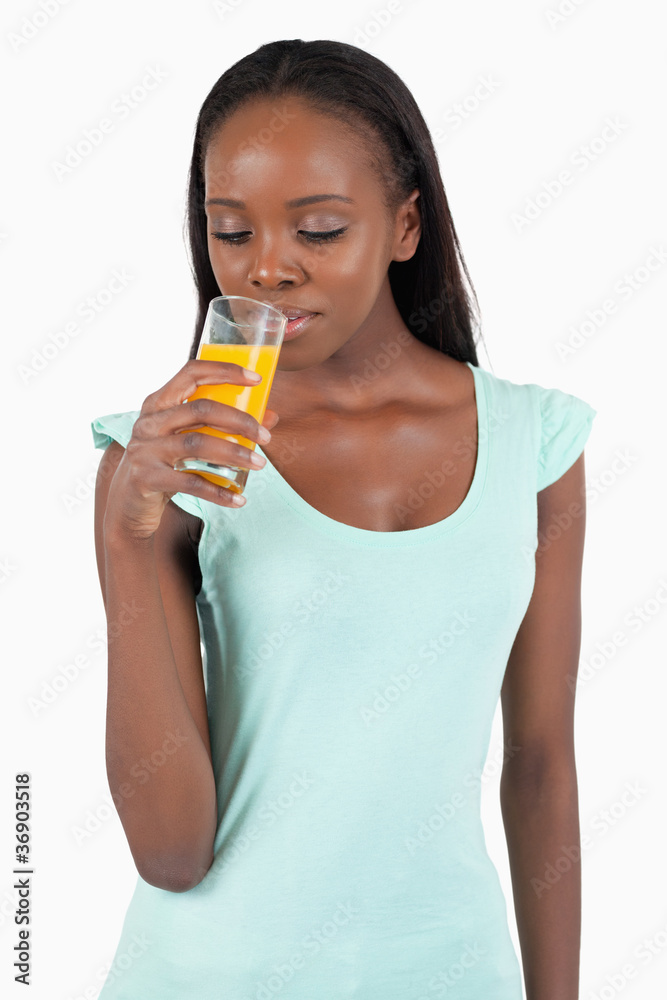 Young woman looking into her glass of orange juice Young woman looking into her glass of orange juice