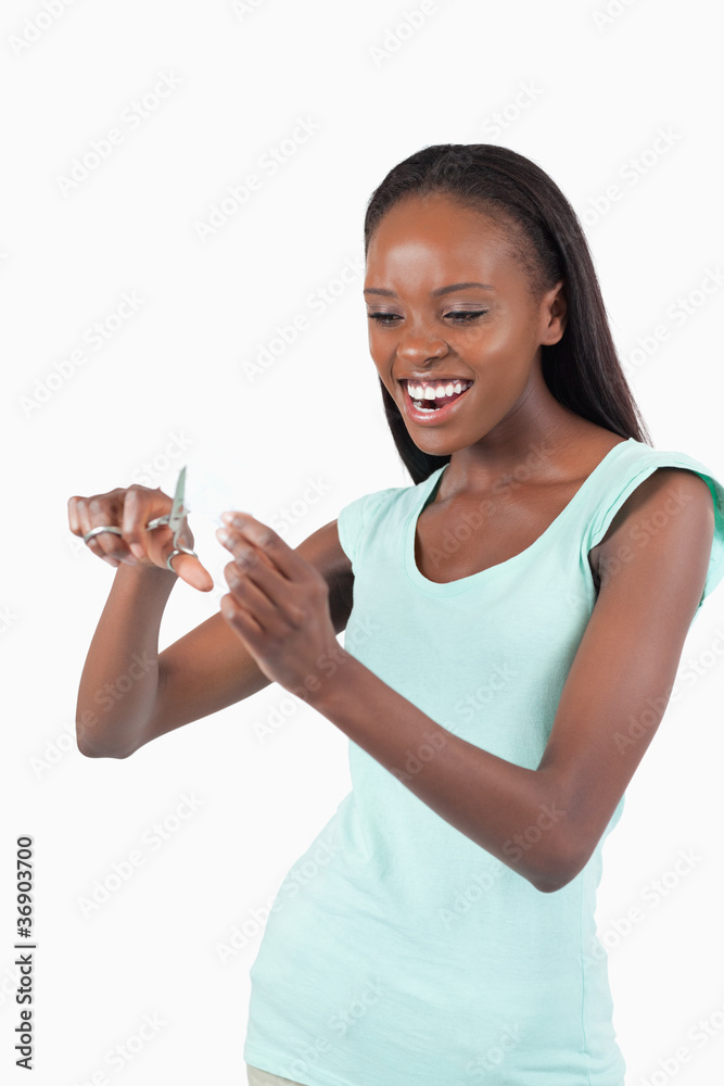 Angry woman cutting her credit card into pieces Angry woman cutting her credit card into pieces