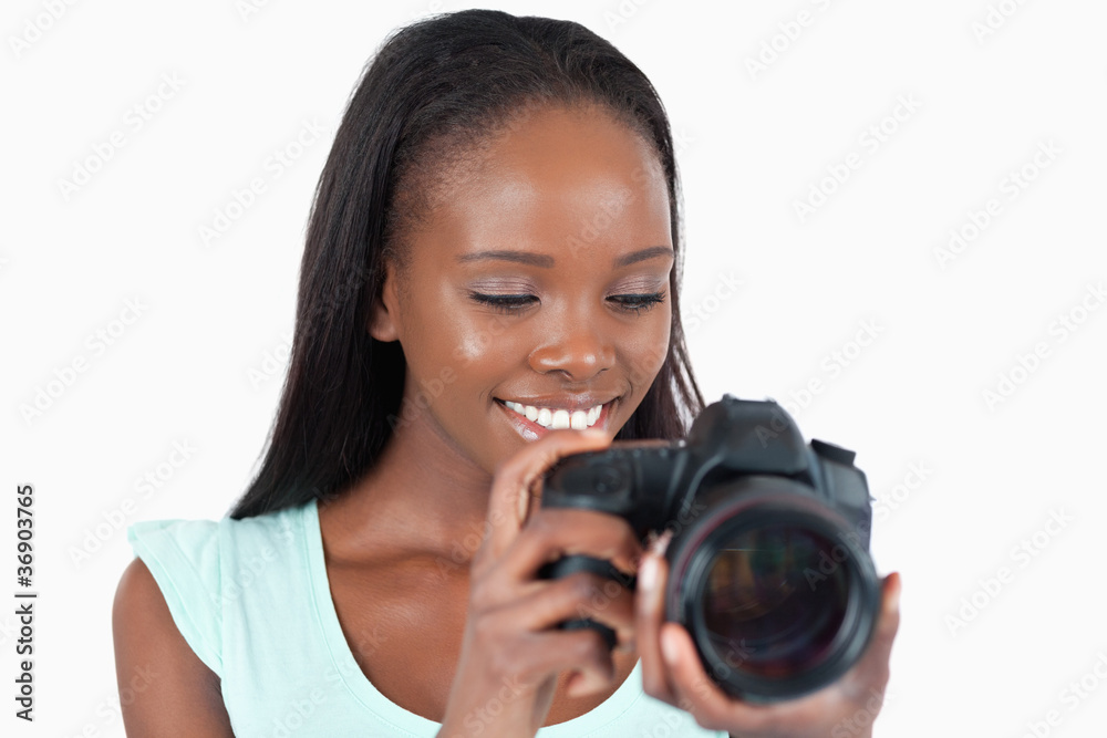 Smiling young photographer having a look at her camera Smiling young photographer having a look at her camera