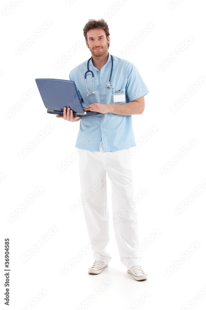 Goodlooking doctor working on laptop smiling Goodlooking doctor working on laptop smiling