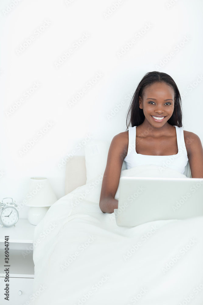 Portrait of a young woman using a notebook before sleeping Portrait of a young woman using a notebook before sleeping