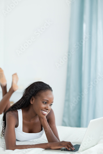 Free Download Portrait of a woman lying on her belly using a notebook - GFXLoad
