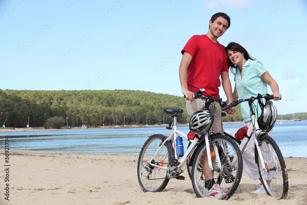 Young couple with bikes on a  beach