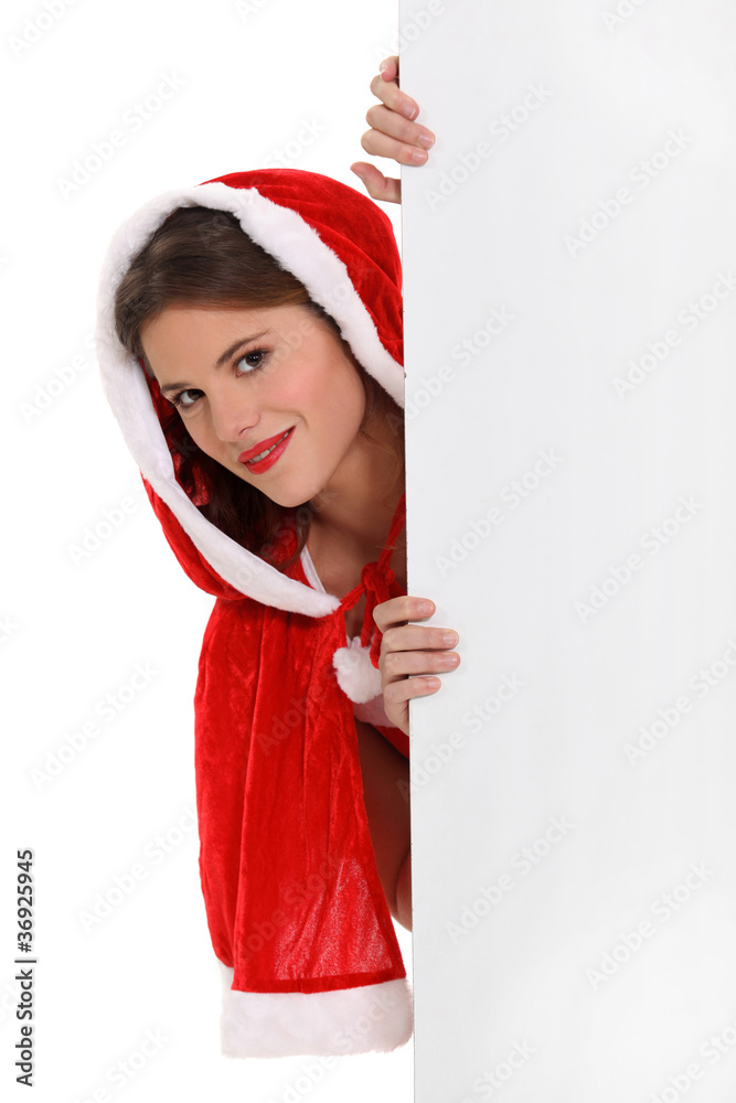 Miss Santa peeking round a board left blank for your message Miss Santa peeking round a board left blank for your message