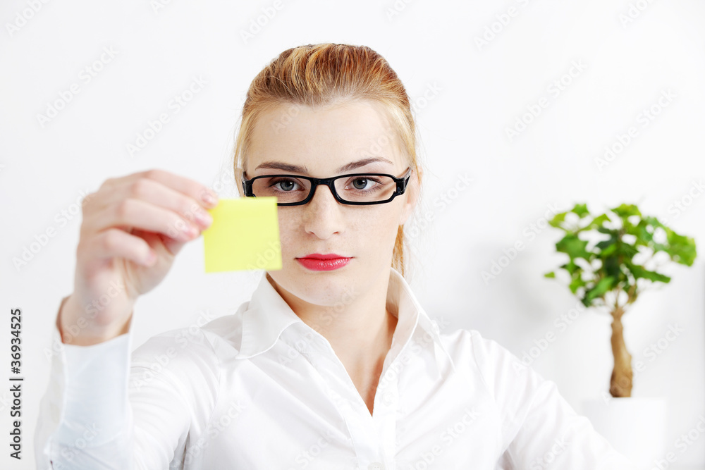 Bussineswoman looking at yellow sheet of paper. Bussineswoman looking at yellow sheet of paper.
