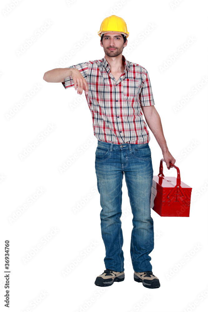 A construction worker carrying a toolbox. A construction worker carrying a toolbox.