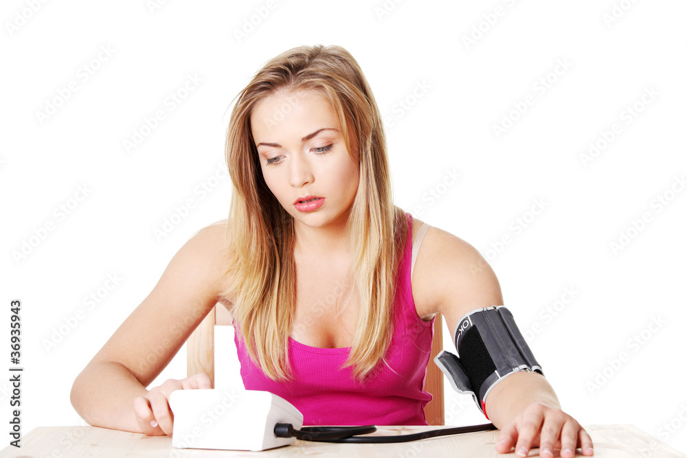 Teen girl checking her blood pressure Teen girl checking her blood pressure