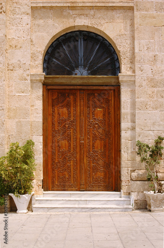 ancient wooden door with arched window above