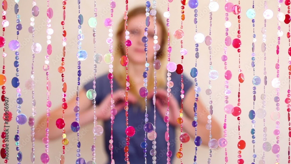 Girl sit behind beads curtain, blurred