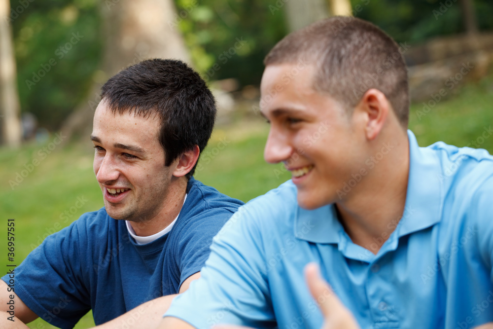 Two young men in conversation at the park Two young men in conversation at the park