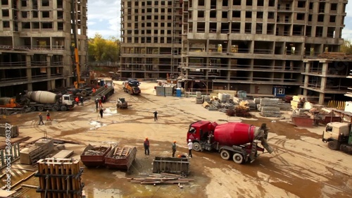 Red concrete mixer arrives on construction site photo