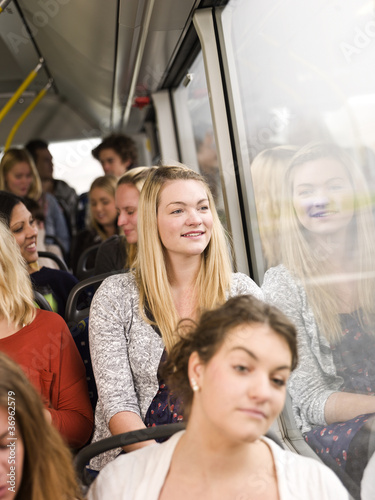 Happy woman on the bus with large group of people