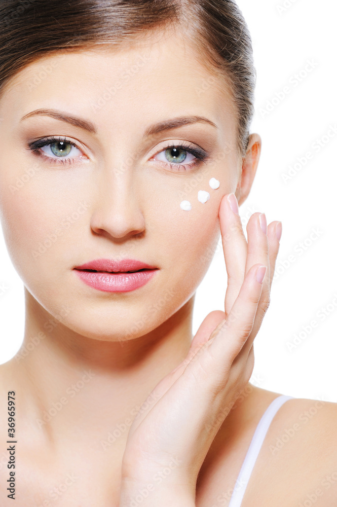 girl applying cream on her skin around eyes girl applying cream on her skin around eyes