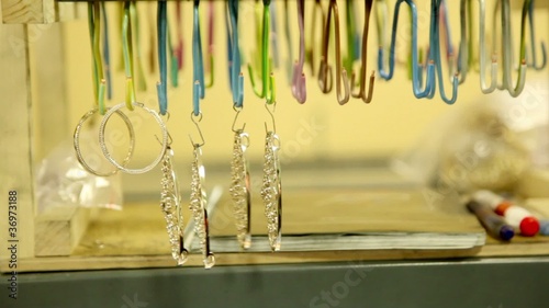 Several jewelry hang on hooks in row, closeup view photo