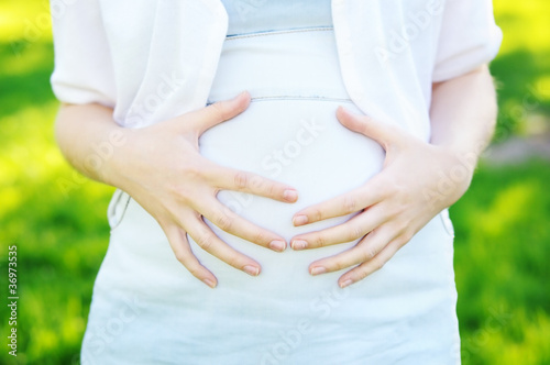 Wallpaper Mural Young woman holding hands on her pregnant belly Torontodigital.ca