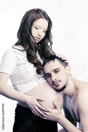 Beautiful future parents: his pregnant wife and a happy husband