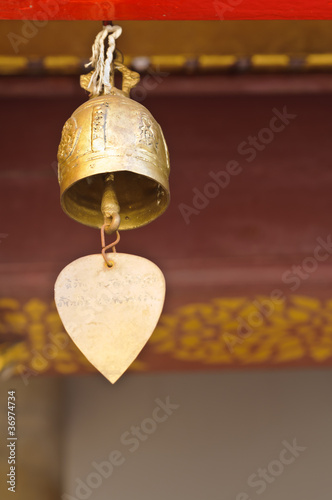a small bell hanging under the temple roof