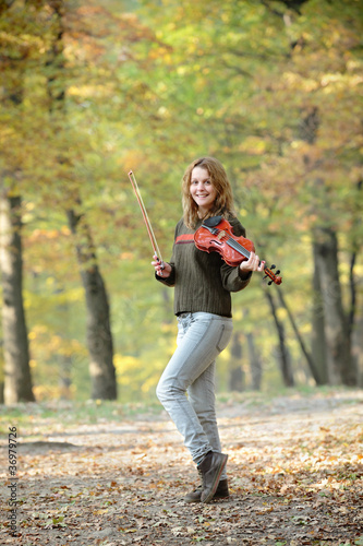 Young girl with violin in forest, selective focus