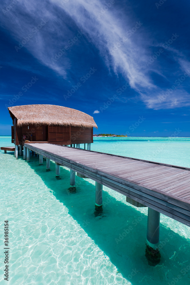 Overwater bungalow in lagoon around tropical island