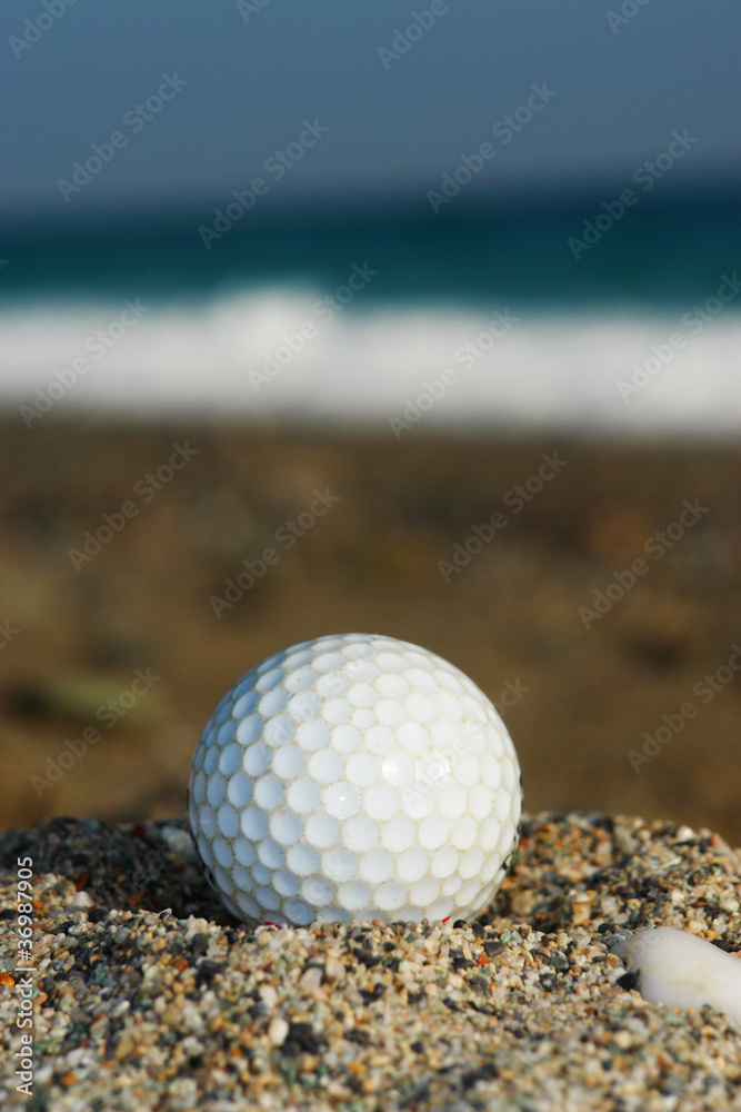 Golf Ball On The Beach, Ready To Be Hit In To The Ocean. Golf Ball On The Beach, Ready To Be Hit In To The Ocean.