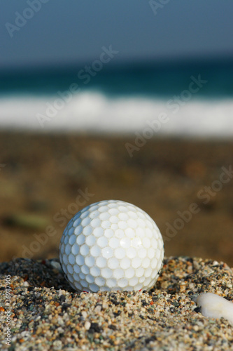Golf Ball On The Beach  Ready To Be Hit In To The Ocean.