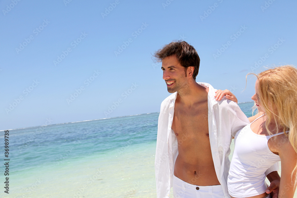 Couple walking on white sandy beach Couple walking on white sandy beach