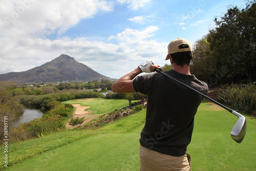Back view of man playing golf
