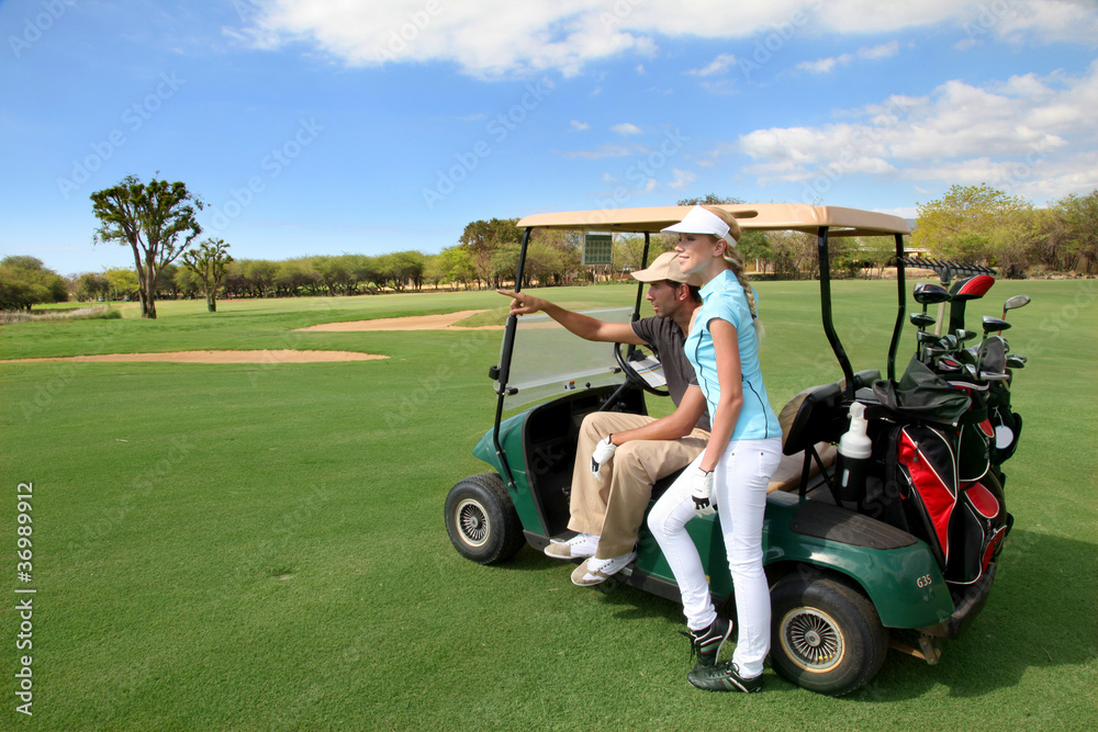Couple on golf course with cart Couple on golf course with cart