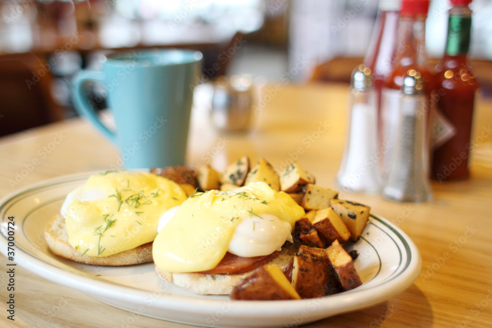 Delicious eggs benedict with seasoned potatoes for breakfast. Delicious eggs benedict with seasoned potatoes for breakfast.