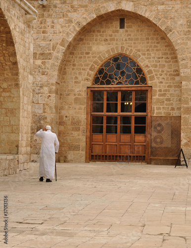 Old muslim men walking inside a mosque.