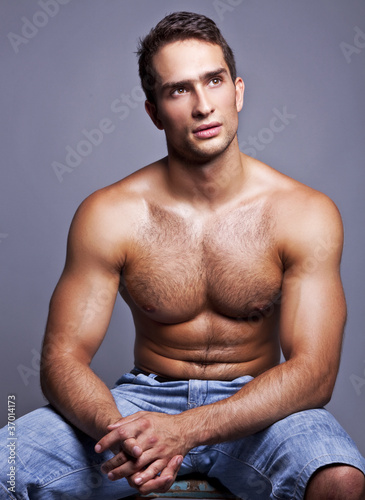 muscular man sitting on a chair
