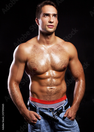 young muscular man isolated on black background