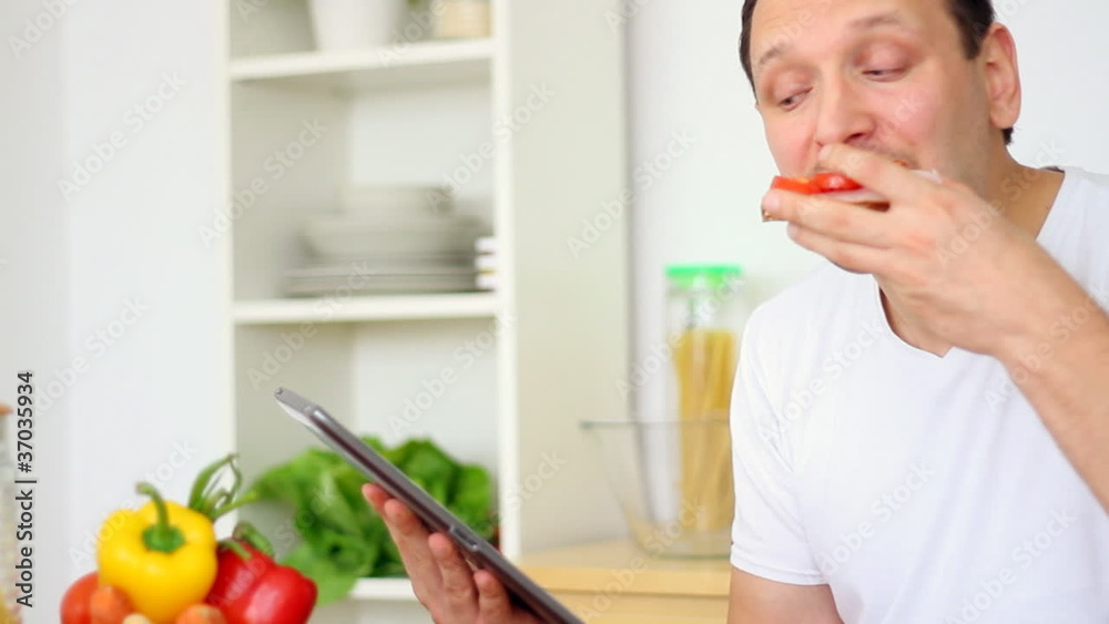 Man eating breakfast and using digital tablet, steadicam shot