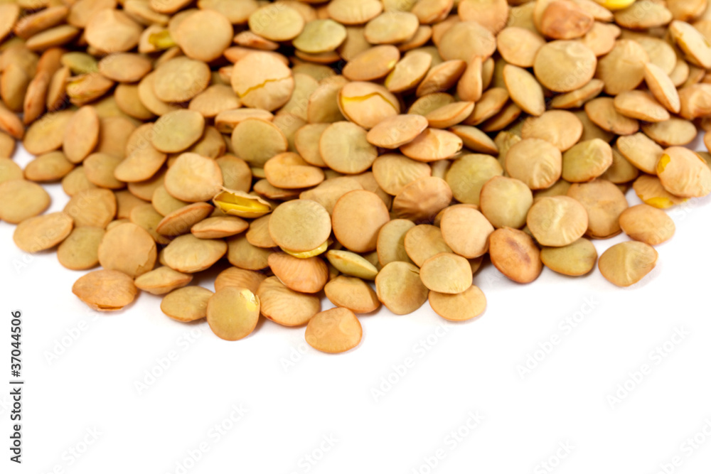 Brown lentils scattered on white background Brown lentils scattered on white background