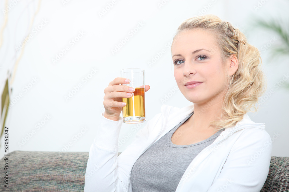 Woman on couch drinking apple juice Woman on couch drinking apple juice