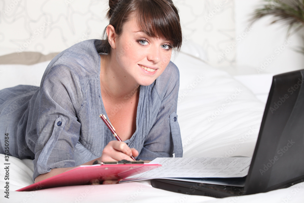 female student working in bed with laptop female student working in bed with laptop