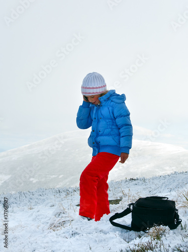 Girl talk by cellphone on mountain winter plateau