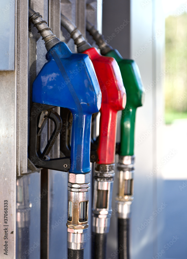 Three Colorful Pump Nozzles At The Gas Station Three Colorful Pump Nozzles At The Gas Station