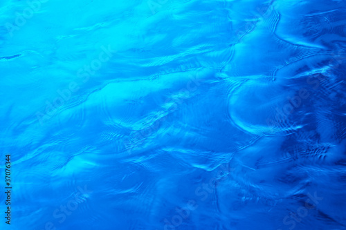 Abstract bright blue water background. Open sea.