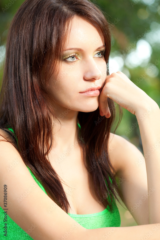 serious woman sitting under the tree closeup face serious woman sitting under the tree closeup face