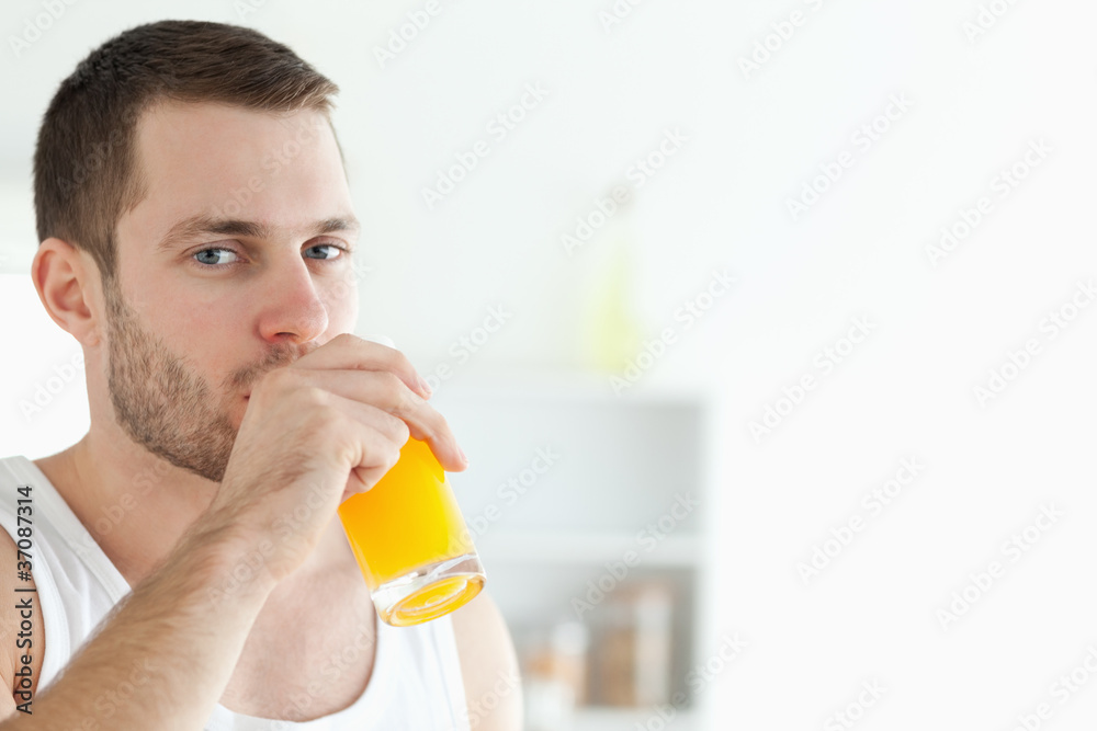 Portrait of a good looking man drinking orange juice Portrait of a good looking man drinking orange juice