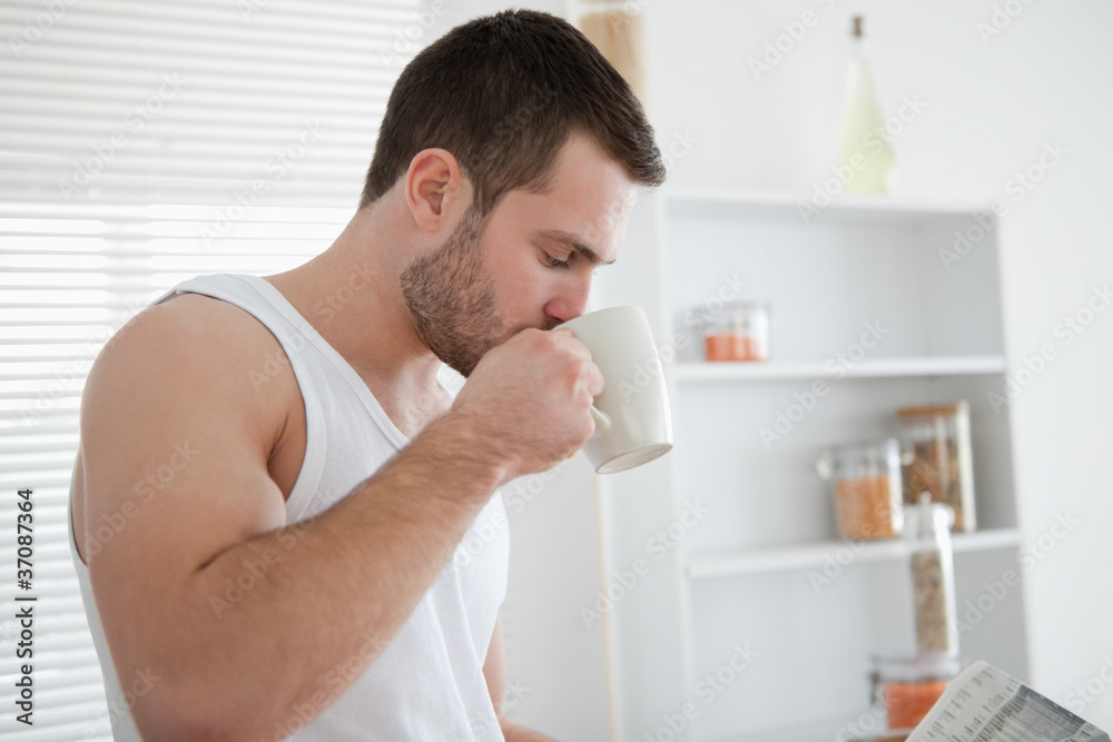 Man drinking coffee while reading the news
