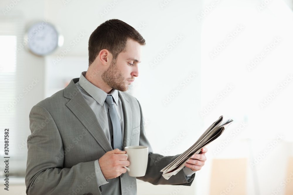 Businessman drinking tea while reading the news Businessman drinking tea while reading the news