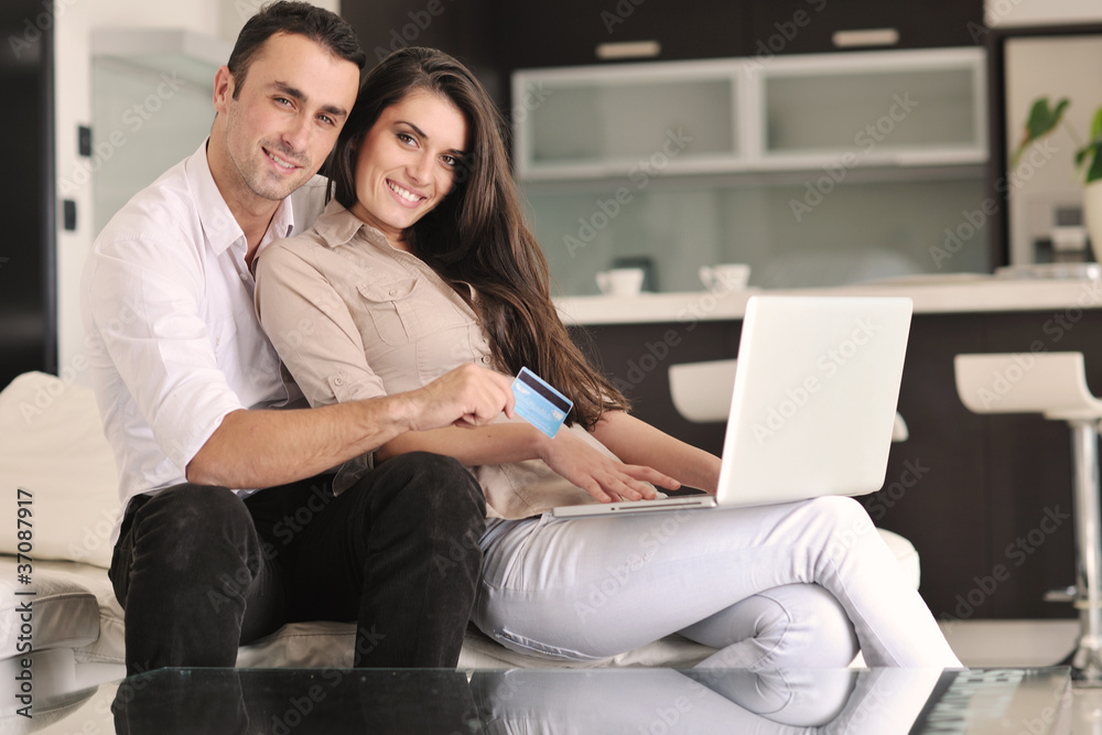 joyful couple relax and work on laptop computer at modern home joyful couple relax and work on laptop computer at modern home