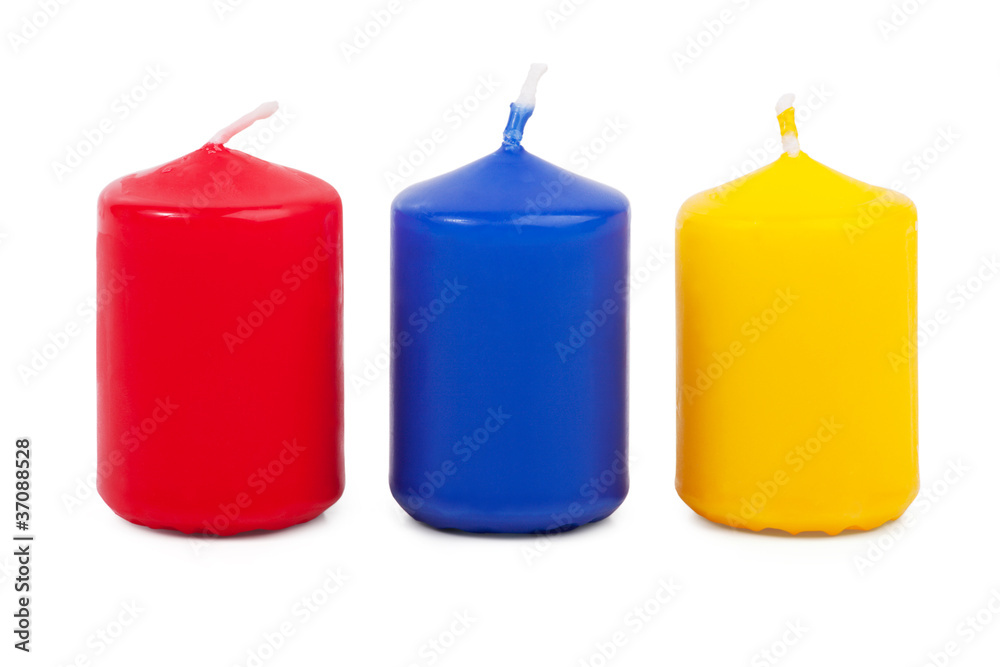 Three little colored candles squat on a white background Three little colored candles squat on a white background